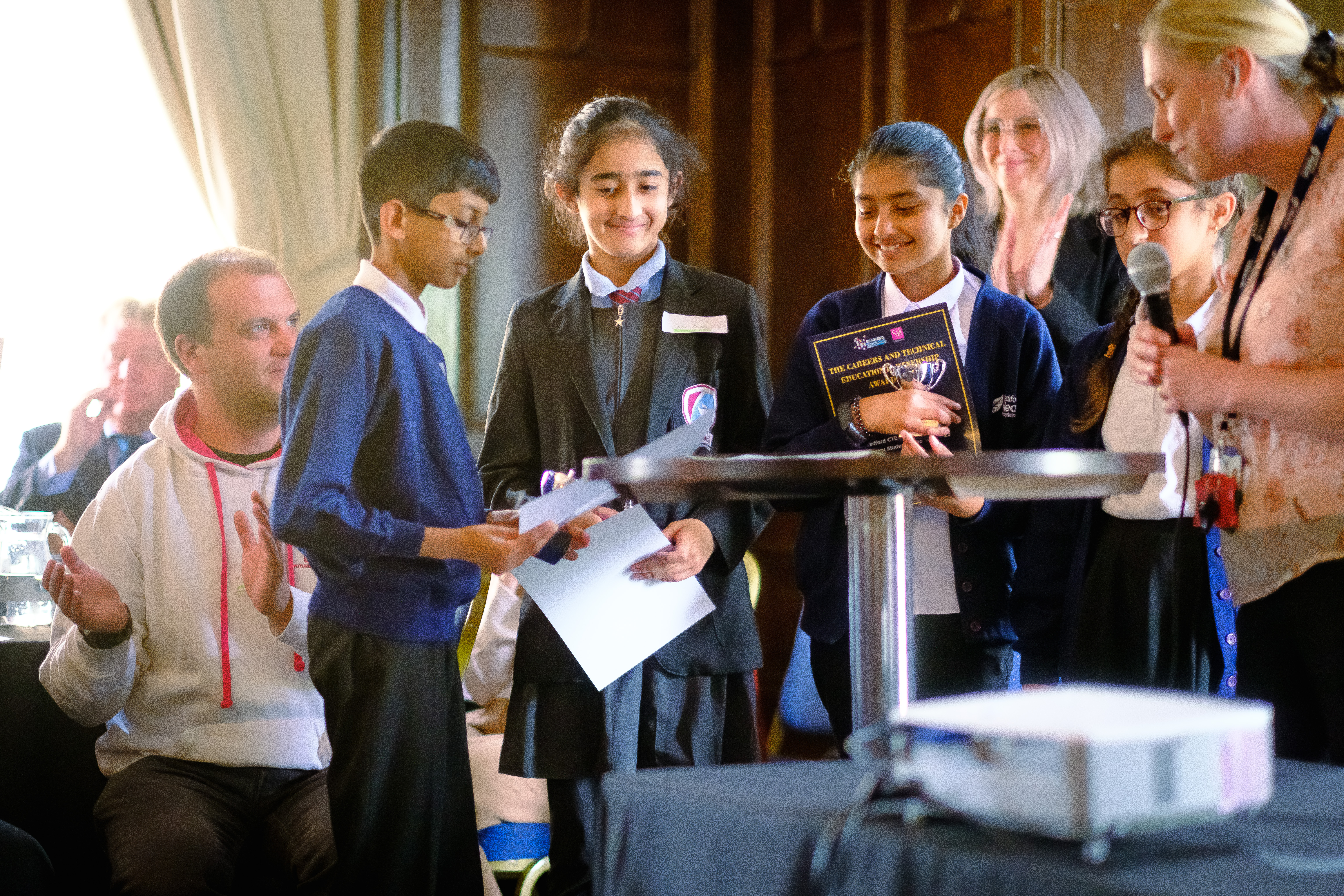 Four young people with certificates and awards
