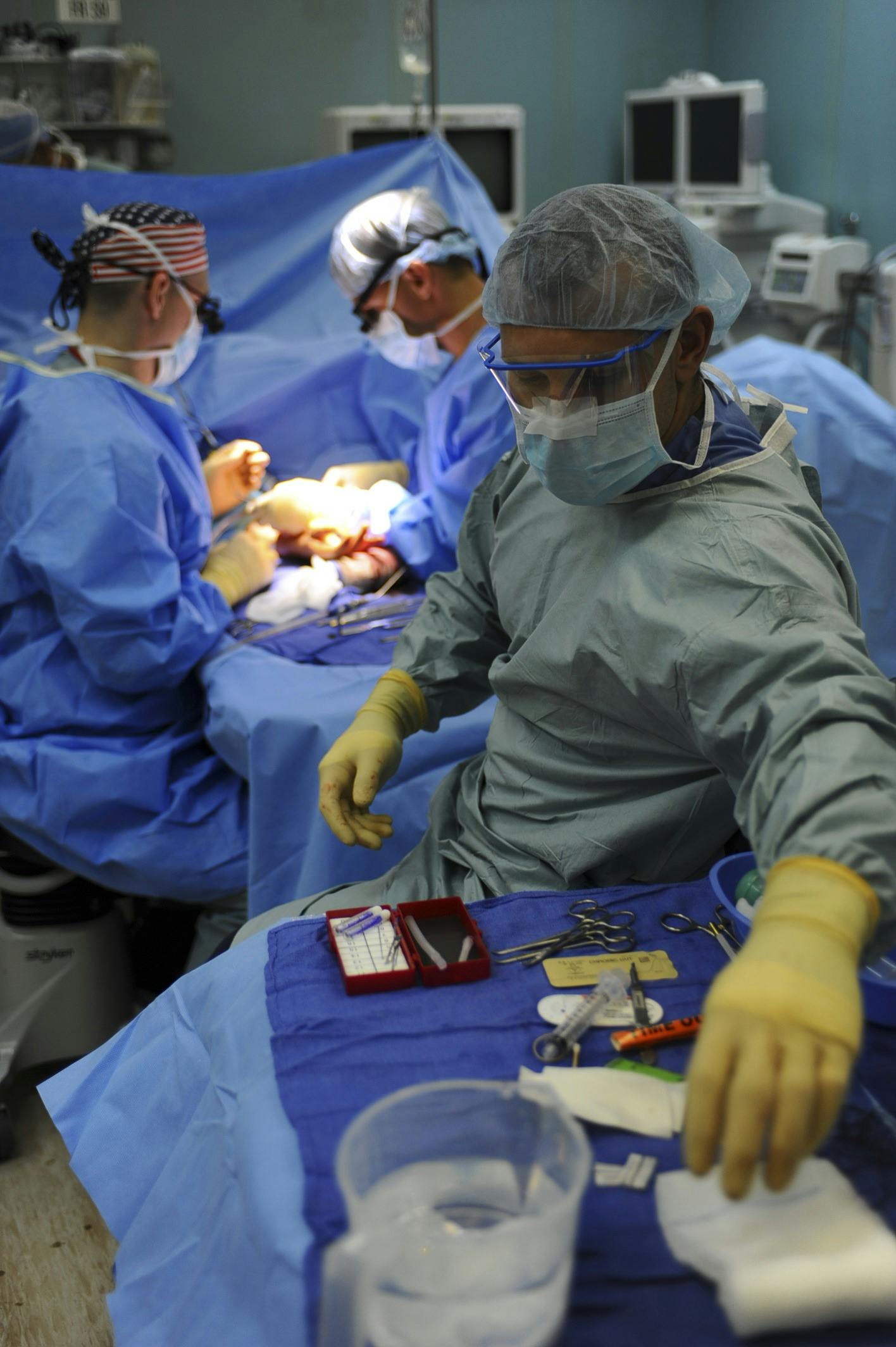 An operating theatre with a group of doctors around a patient