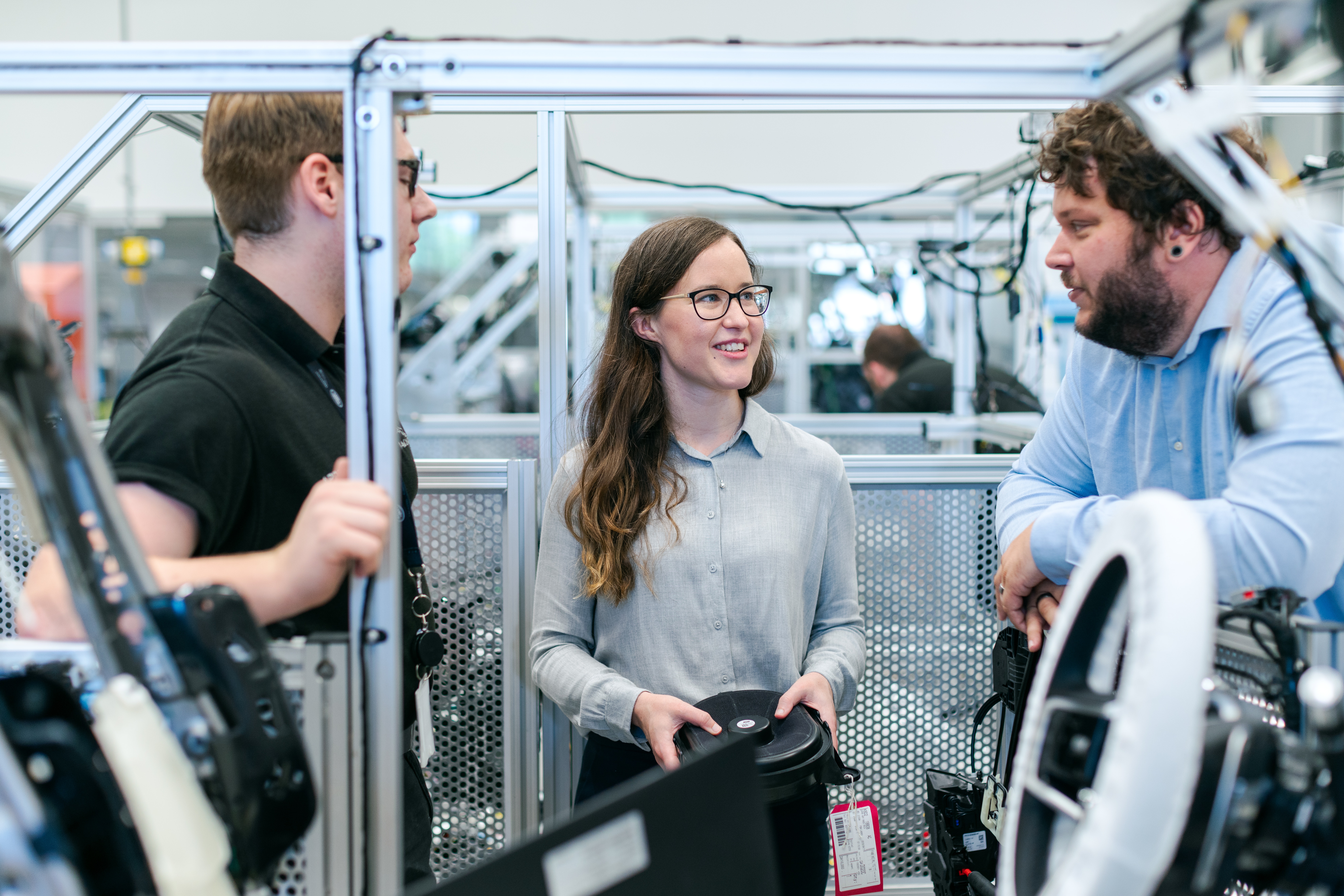 Three young people in a factory or workshop