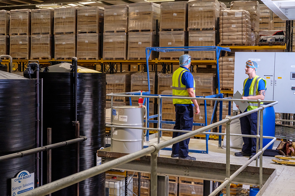 Two men in protective clothing in a factory