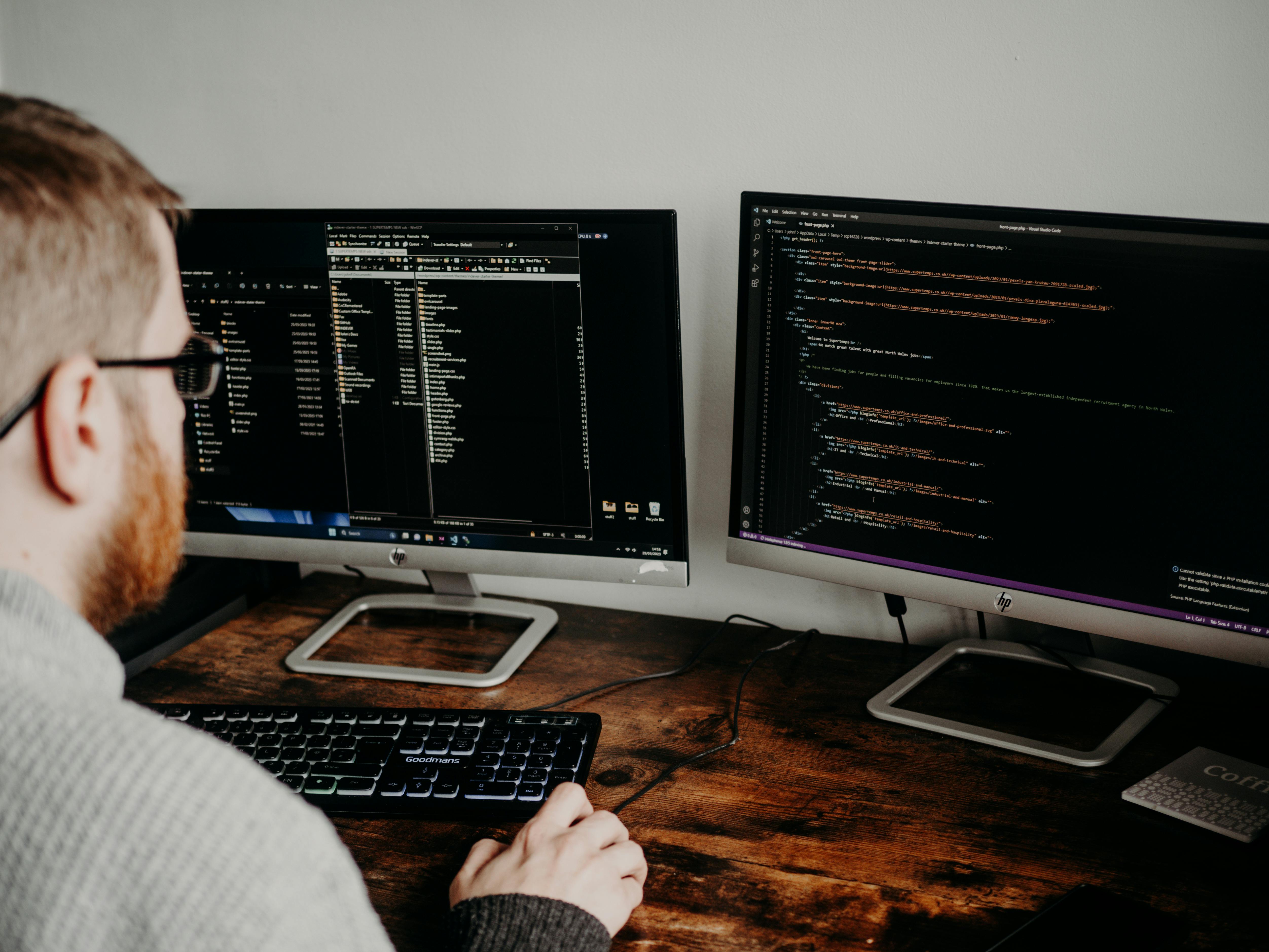 A man working on two computer screens