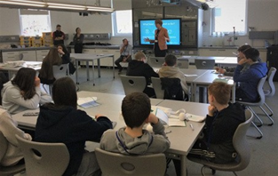 A group of young people in a classroom watching a presentation