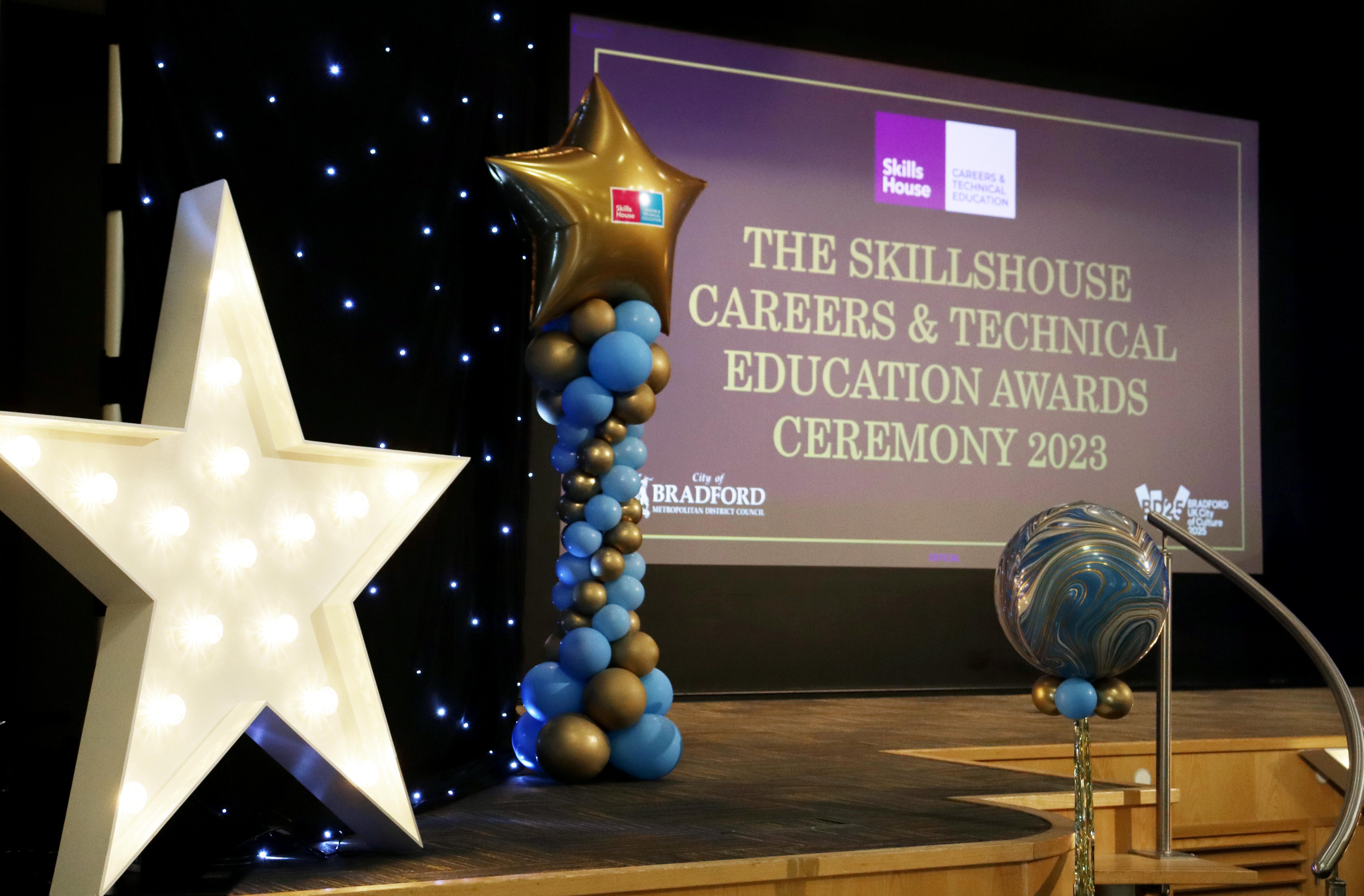 A stage set with presentation, large lighted star and balloons
