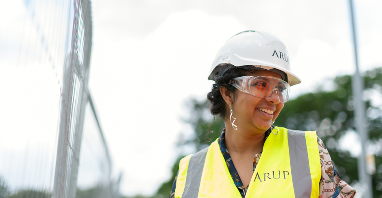 Woman wearing hard hat and hi-vis jacket on a construction site