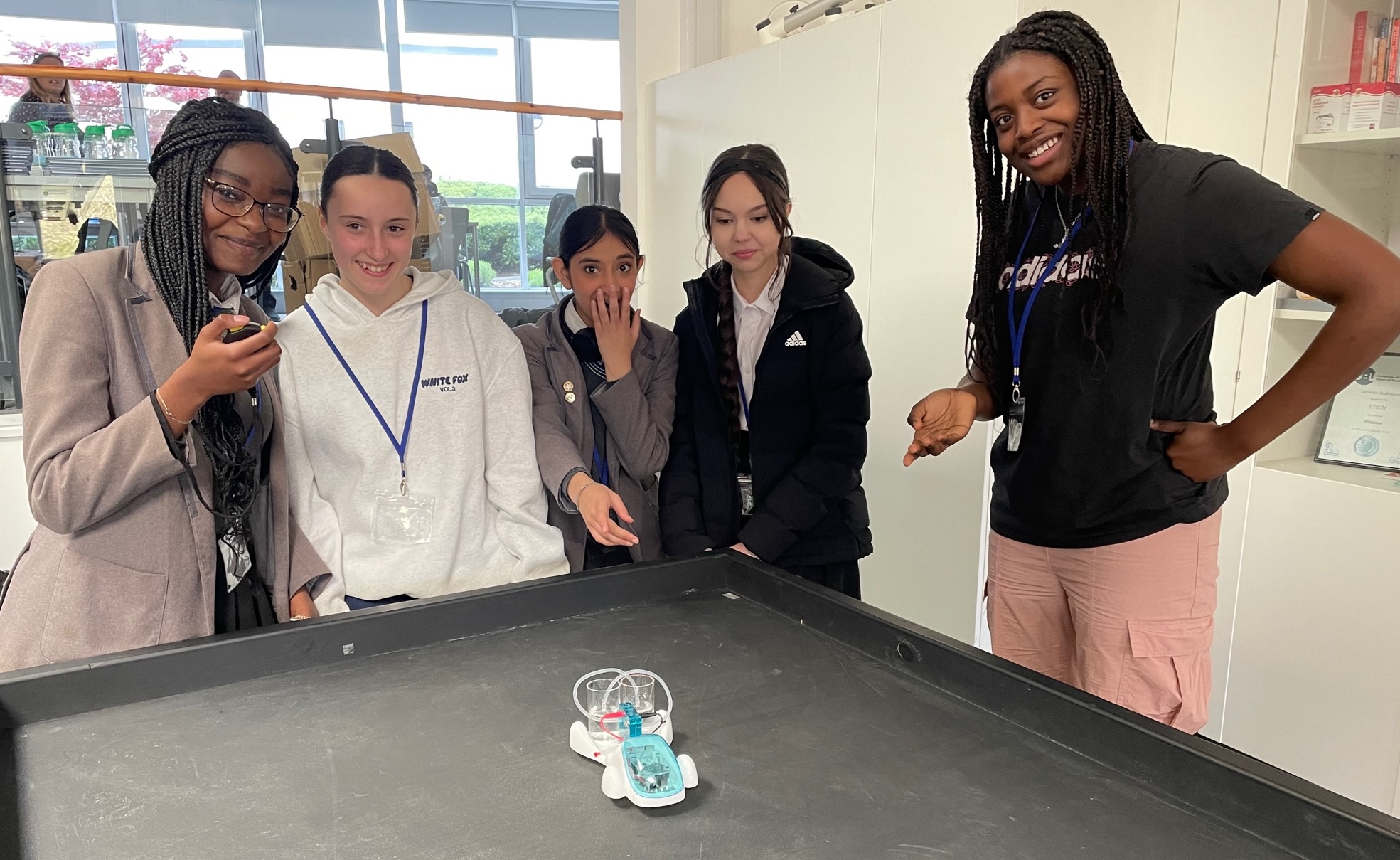 A group of students with a small water-powered vehicle
