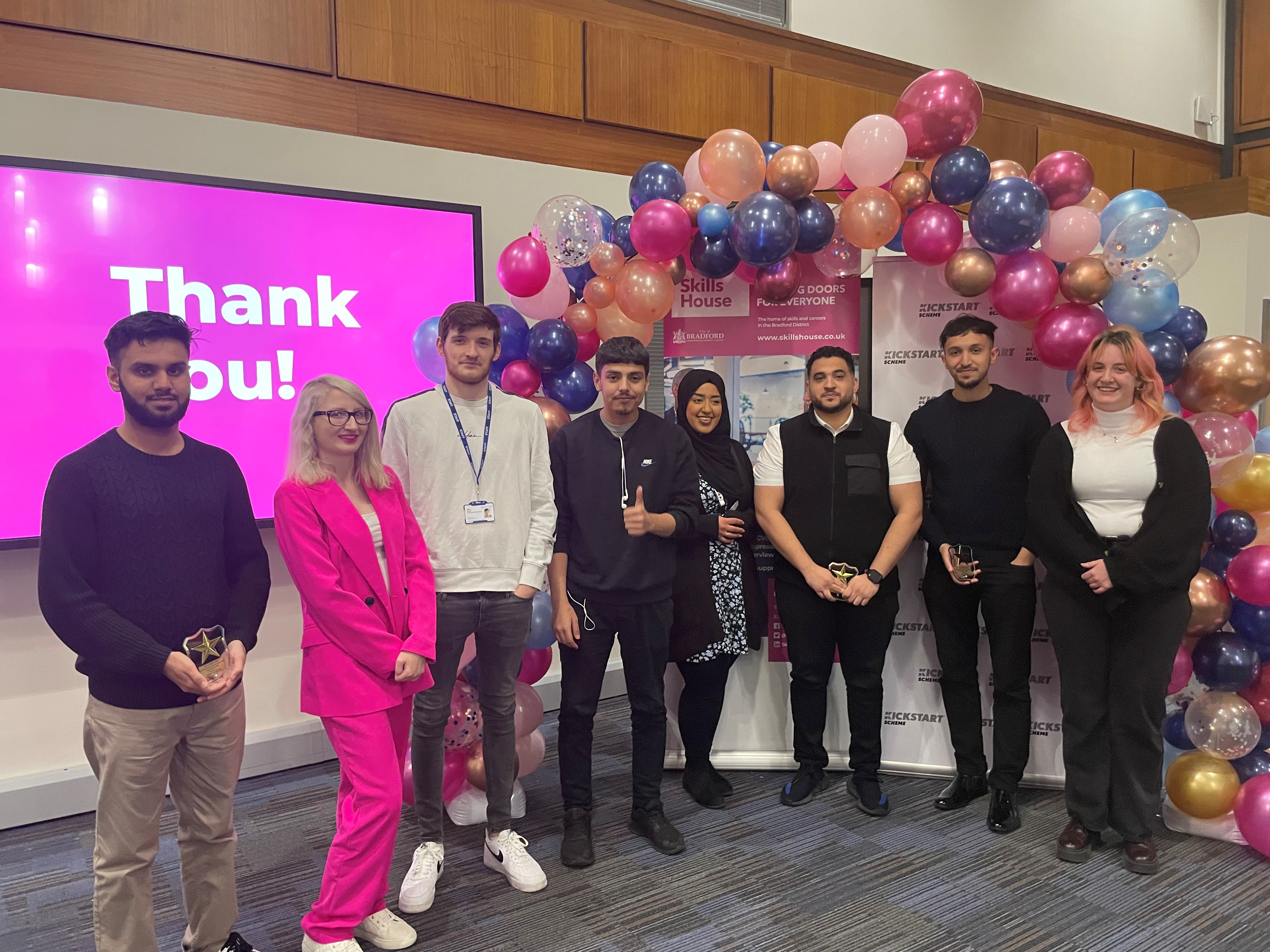 A group of young people stood in front of a balloon arch