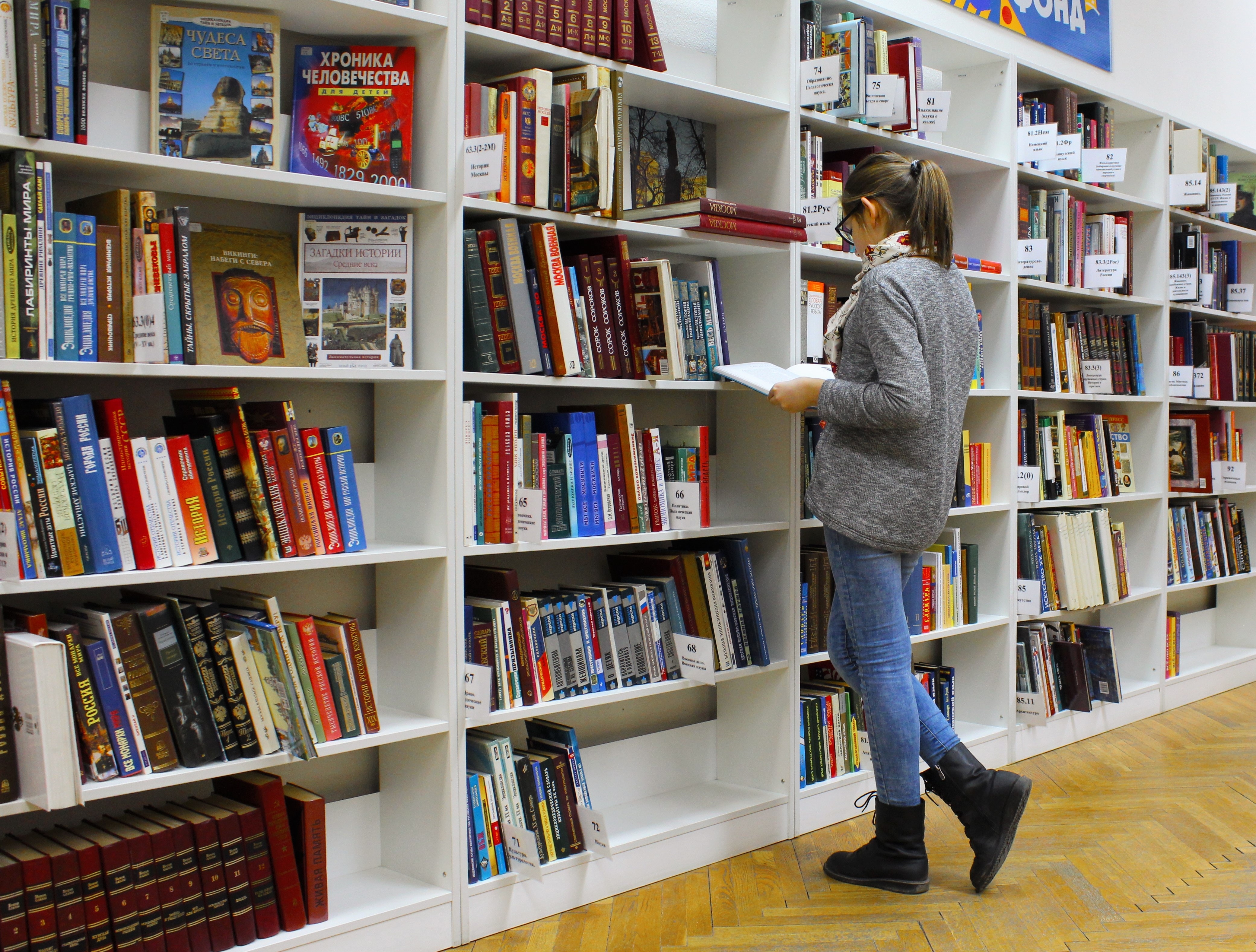 A woman browsing the shelves of a library