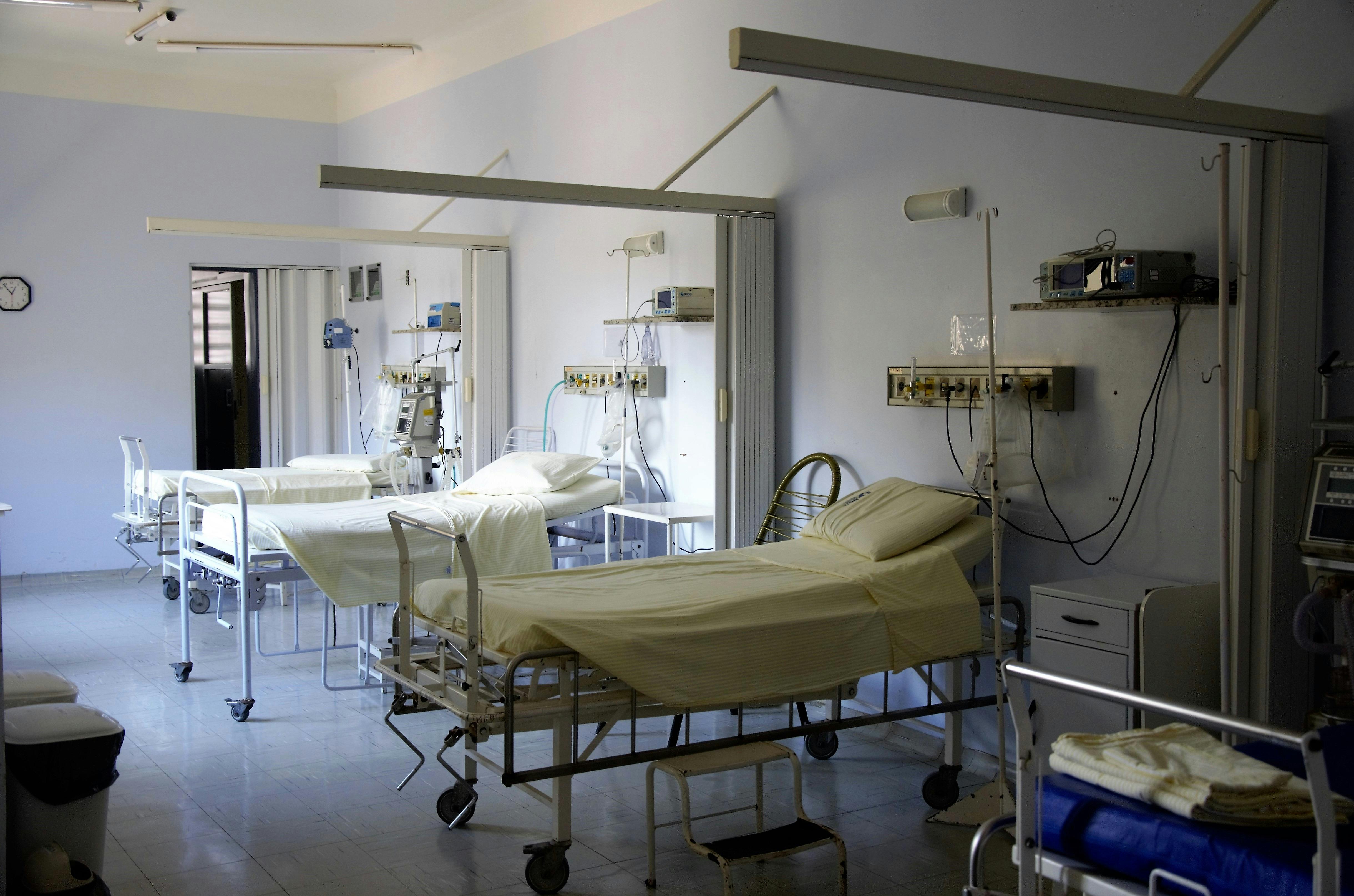 A group of hospital beds on a ward
