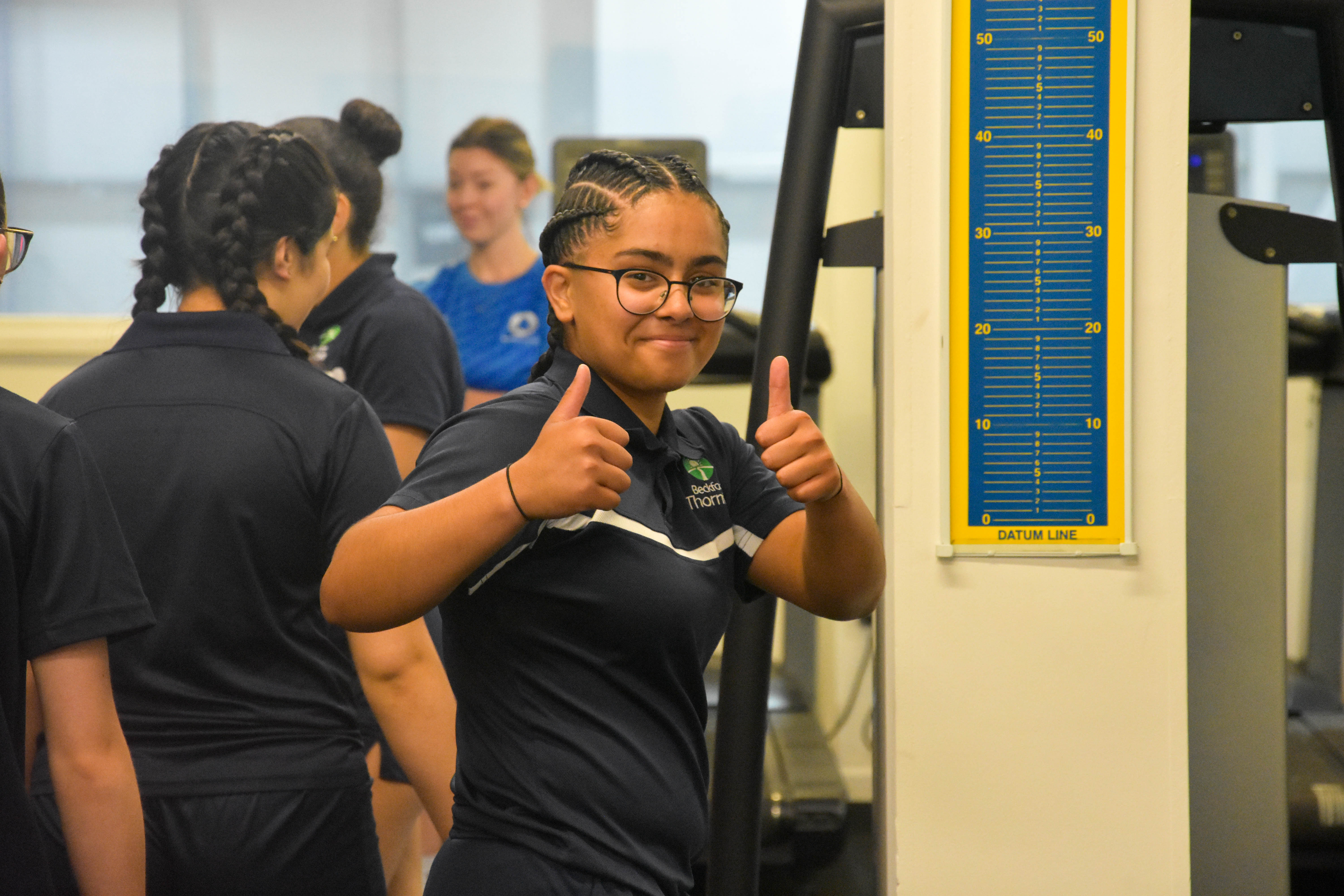 A girl in sportswear giving two thumbs up