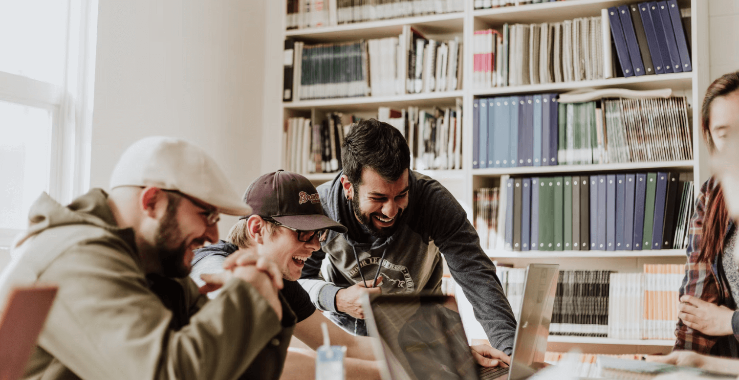 A group of young people looking at a laptop computer
