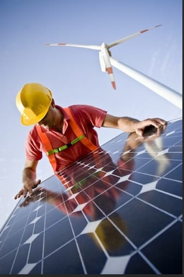 A man in hi vis and a hard hat looking at solar panels
