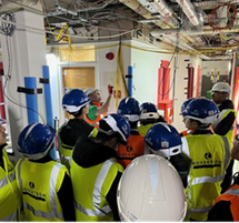 A group of young people wearing high vis jackets and hard hats