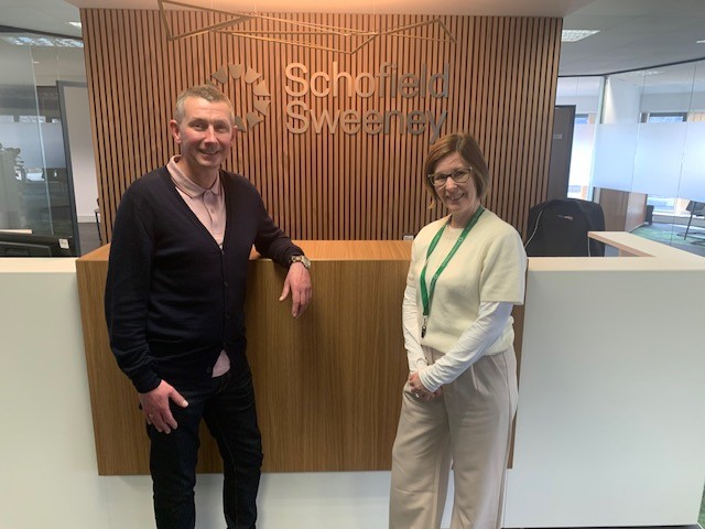 Two people in front of the Schofield Sweeney reception desk