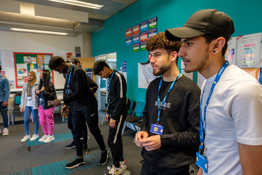 A group of young people wearing lanyards stood at the front of a classroom