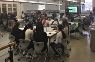 A group of young people in a classroom watching a presentation